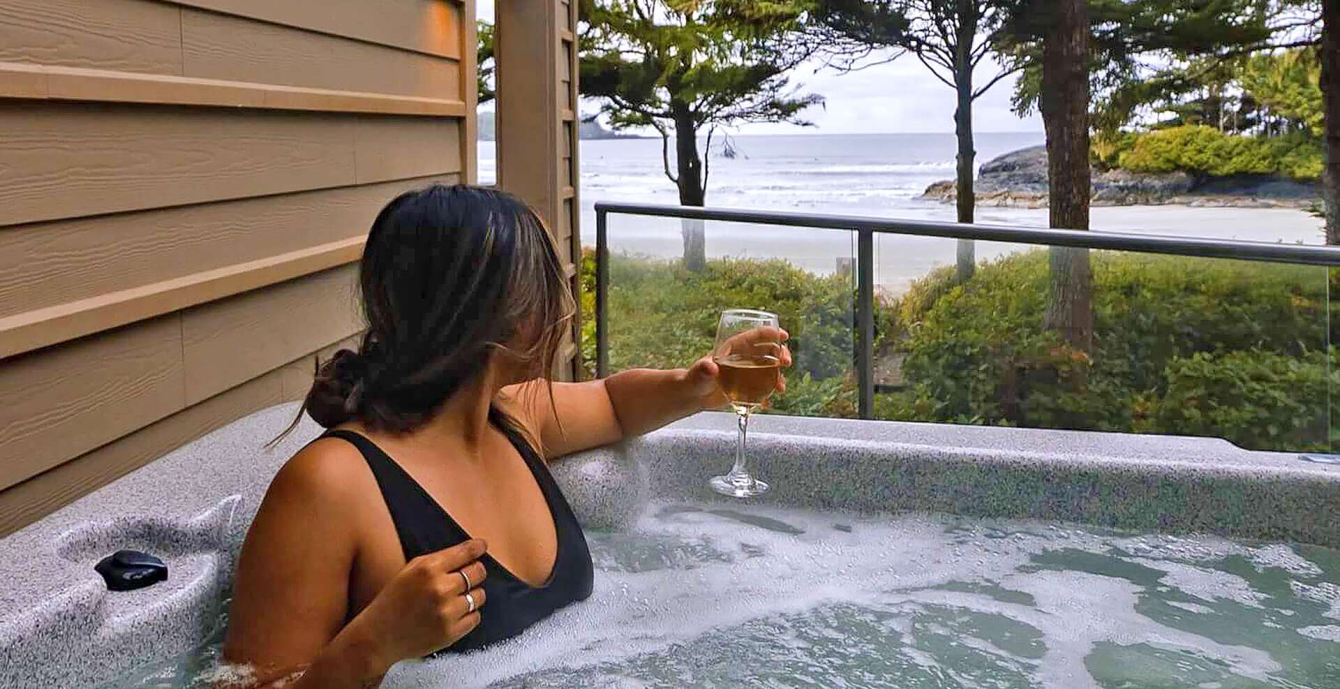 Girl in hot tub with beverage enjoying the ocean views.